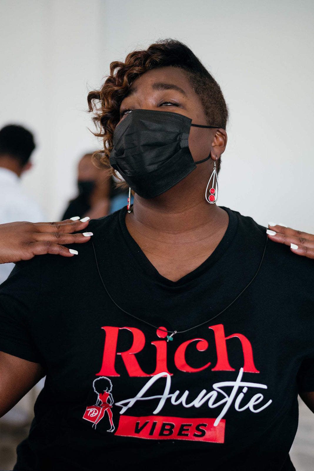 Black woman wearing black face mask and black t-shirt that says 